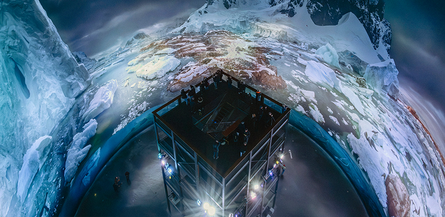 Panoramainnenraum vom Panometer Leipzig. Zu sehen ist das Panorama groß aufgespannt und in der Mitte des Raumes der Besucherturm mit vielen Menschen.