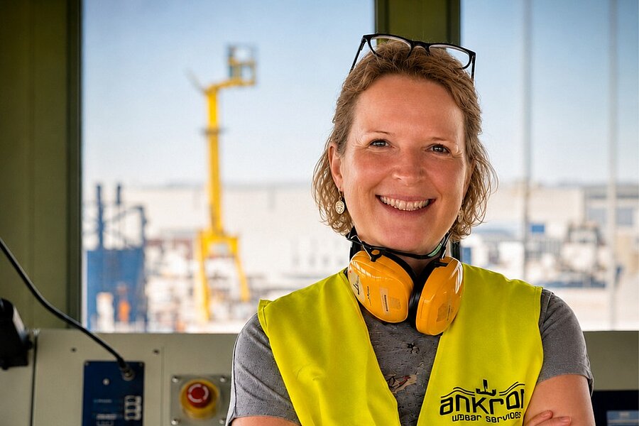 Die Biologin Dr. Anette Küster trägt eine gelbe Weste und lächelt in die Kamera.